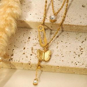 Detail of gold double-layer necklace with butterfly pendant and crystal on stone base