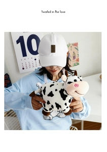 Detail of cute cartoon cow plush crossbody bag featuring soft black and white cow print fur