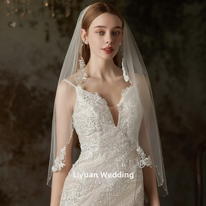 Detailed close-up of white bridal veil with floral lace appliques and sequin embroidery