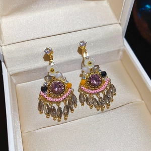 Detail of vintage bohemian earrings with purple gemstones and grey crystal tassels
