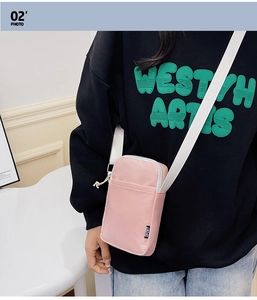 Detail of pink canvas crossbody phone bag featuring SPORT label and white strap