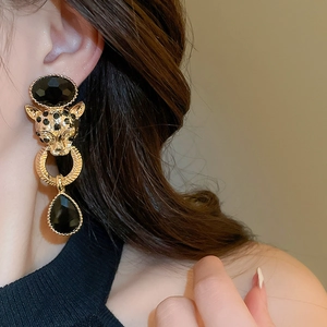 Detail shot of vintage cheetah door knocker earrings with black crystal drop on model