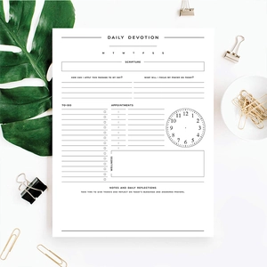 Flat lay of daily devotion planner page with stationery and tropical leaf detail