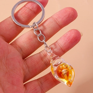 Close-up of a glowing conch shell keychain with a transparent resin pendant and metal ring