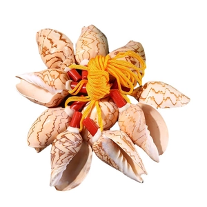 Natural conch shell whistles with red-white tubes on a yellow string, traditional craft toy