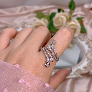Macro detail of silver multi-layer spiral star ring with pavé zircons on pink silk
