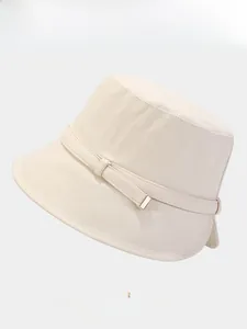 Detail of cream bucket hat with adjustable metal buckle and woven texture closeup
