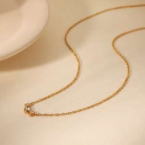 Detail of 18K gold stainless steel chain with three curved clear zircon crystals