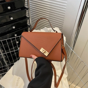 Brown crocodile pattern crossbody bag with gold buckle lock and adjustable leather strap