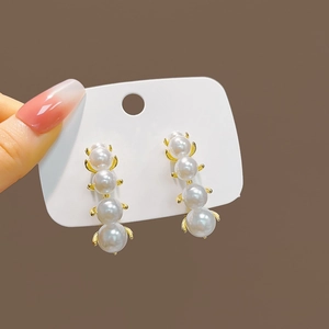 Elegant gold drop earrings featuring four vertical white pearls on a minimalist base