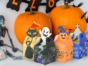 Detail of Halloween candy boxes with ghost and pumpkin designs in a party scene
