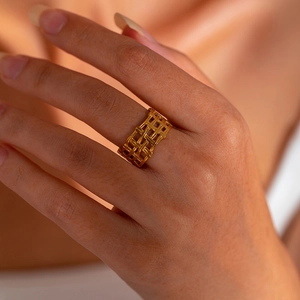 Close-up of golden hollow woven texture on vintage wide-band stainless steel ring