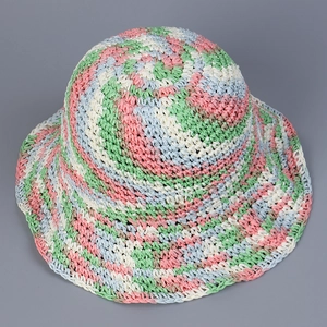 Macro shot of colorful handmade woven straw sun hat with spiral pattern texture