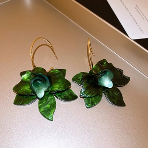 Elegant dark green resin flower drop earrings with golden hooks on a luxury tray