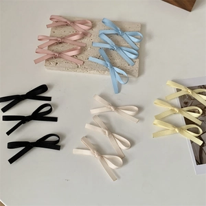 Detailweergave van Franse kanten strik haarspelden in roze, blauw, zwart, beige en geel