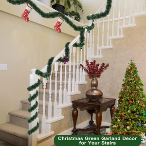 Christmas green garland with red socks and bows decorating a white staircase handrail