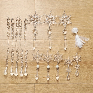 Transparent acrylic snowflake and icicle Christmas ornaments set on a wooden surface