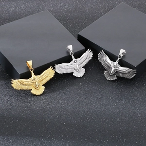 Detailed view of gold and silver eagle pendants with polished and vintage finishes