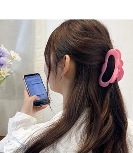 Matte pink large hair claw clip with wavy edges styled on model for elegant hair styling