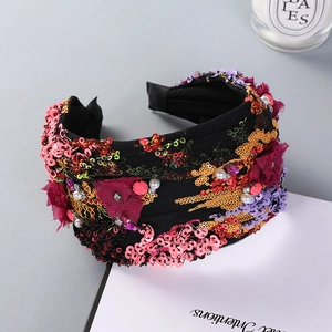 Detail of wide headband with colorful sequins, pearls and embroidered floral accents