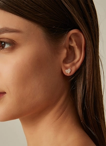 Close-up of a 14K gold plated heart stud earring with pavé zircon stones on a model