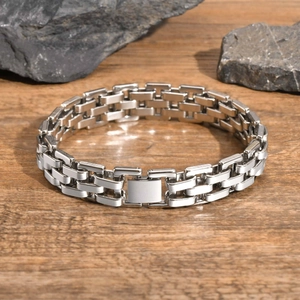 Close-up of silver stainless steel watch-band style bracelet on rustic wood and stone
