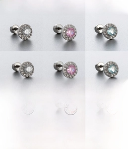 Macro detail of titanium steel tragus studs with white, pink, and blue cubic zirconia