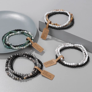Close-up of 4mm natural stone beaded bracelets set with rustic paper tags in gift display