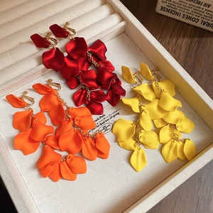 Detail showing long petal tassel earrings in red, orange, and yellow matte finish