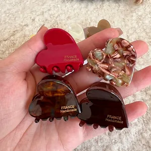 Elegant heart-shaped acetate hair claw clips with gold handmade branding in four colors