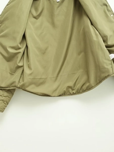 Detailed close-up of olive green jacket interior lining with size XS and care label