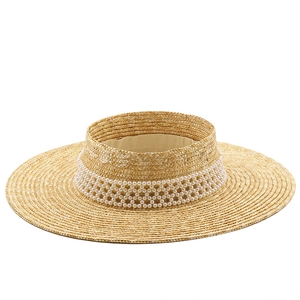Detailed texture of woven straw sun hat with elegant rows of white pearl embellishments