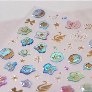Macro detail of laser gold nail art stickers with swan butterfly and shell patterns