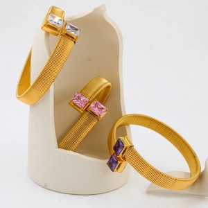 Gouden elastische roestvrijstalen armband met vierkante stenen in wit roze en paars