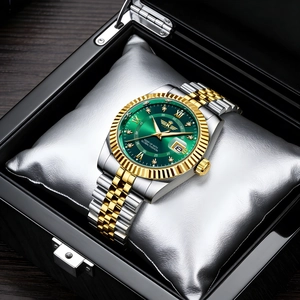 Detailed macro of a luxury men's watch with green dial and calendar in a black gift box