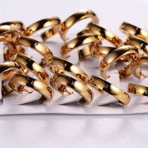 Golden minimalist stainless steel huggie hoop earrings arranged on a white display card
