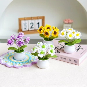 Handmade knitted lily of the valley and sunflower potted plants on white ceramic pots