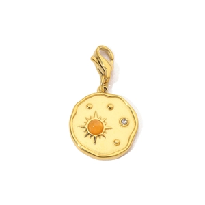 Macro detail of sunburst charm with orange stone, gold lobster clasp and white zircon