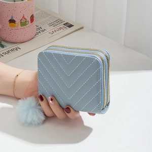 Petit portefeuille bleu clair à double zip avec motif matelassé en V et pompon