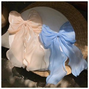 Detailed close-up of mermaid blue and champagne tulle bow hair clips with soft shimmer