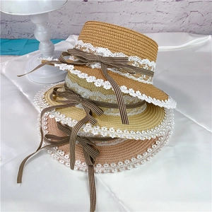 Close-up of three stacked straw hats with white lace edges and brown checkered ribbons