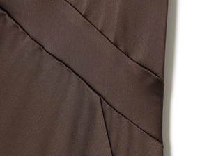 Macro shot of dark brown satin dress fabric with smooth texture and fine stitching