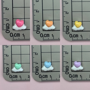 Detailed size comparison of colorful resin heart and cloud charms on a ruler