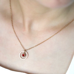 Minimalist gold necklace with geometric circular pendant and red birthstone for women
