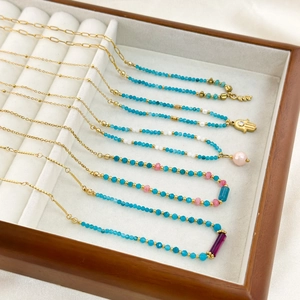 Halskette mit blauen Chalzedon-Perlen und Hamsa-Hand-Anhänger in einer Holzschmuckbox
