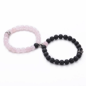 Detail view of pink quartz and black lava stone couple bracelets with magnetic crown charms