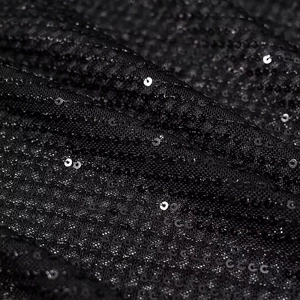 Macro shot of shimmering black sequins on high-quality fabric texture for elegant dress