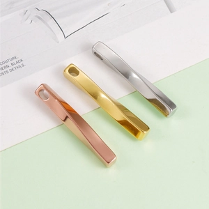 Detailed view of twisted geometric bar pendants in rose gold, gold, and silver finishes