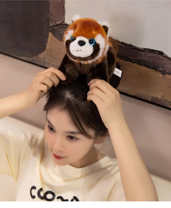 Detailed close-up of a plush red panda toy with fluffy fur texture and blue sequin eyes