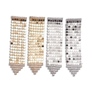 Boucles d'oreilles pompon en or 18 carats et argent avec zircons sur fond blanc épuré